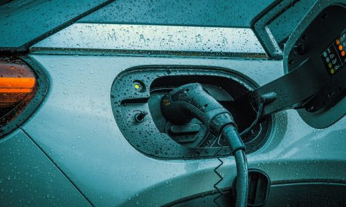 Electric vehicle charging port with cable connected, showcasing seamless installation for home EV chargers, relevant to Downlight Electrical's services.