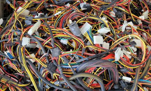 Tangled mass of electrical wiring and connectors, illustrating the complexity of electrical installations relevant to EV charger setups and maintenance.